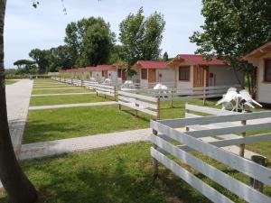 a white fence in front of a row of houses at CirceMed Glamping in San Felice Circeo