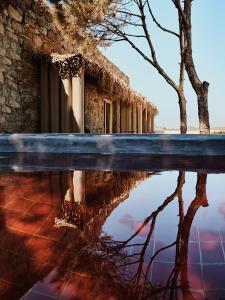 a reflection of a building in a pool of water at The Wild by Interni in Kalafatis