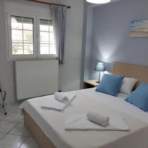 um quarto com uma cama grande e toalhas em Lefkada Blue - Apartments em Lefkada Town