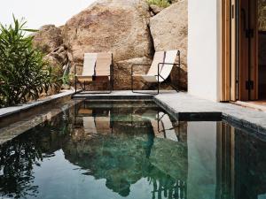 two chairs sitting next to a swimming pool at The Wild by Interni in Kalafatis