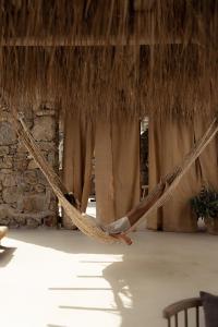 two hammocks hanging from a thatched roof at The Wild by Interni in Kalafatis