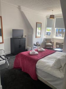 ein Schlafzimmer mit einem großen Bett mit einer roten Decke in der Unterkunft Ellwyn House in Edinburgh