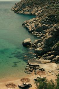 a beach with umbrellas and chairs and the water at The Wild by Interni in Kalafatis