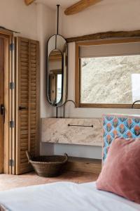 a bedroom with a bed and a mirror and a window at The Wild by Interni in Kalafatis