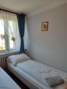 un letto in una camera da letto con finestra di Mieszkanie Słoneczny Sandomierz a Sandomierz