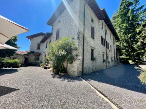 an old stone building with a driveway at B&B Il Castellaccio - Albavilla in Albavilla