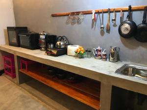 a kitchen with a counter top with a sink and utensils at yoshen Villa in Unawatuna +30 photos