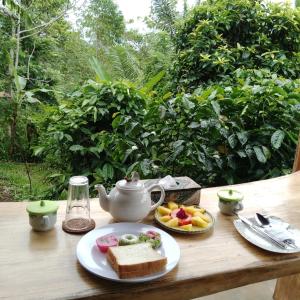a table with a tea pot and a plate of food at Bali jungle cabin in Jatiluwih
