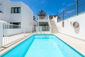 a swimming pool in front of a house at Apartamentos Erika - Adults Only in Corralejo