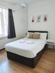 1 dormitorio con 1 cama grande con sábanas blancas en Horizon, en Brighton & Hove