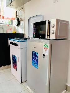 a kitchen with a microwave on top of a refrigerator at Khalisee homes 2 bedroom apartment in Bamburi in Mombasa