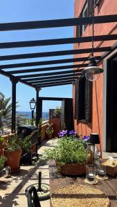 eine Terrasse mit Pflanzen und Markise auf einem Gebäude in der Unterkunft Casa Moni Ferienwohnung mit Meerblick in Playa de Santiago
