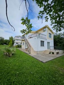 a white house with a staircase in a yard at Gabi 1 in Ðuraševići +4 photos
