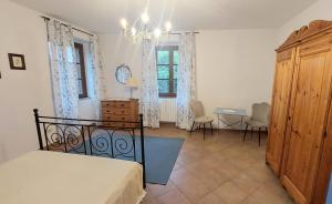 a bedroom with a bed and a table and chairs at Cascina della Chiesa in Ponzone