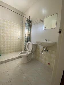 a bathroom with a toilet and a sink at Prime Lodge Hotel in Romblon