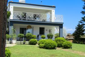 a white house with a balcony on top of it at LefCoast SENSUS Apartments in Paralía Avdhíron