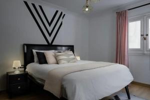 une chambre avec un grand lit avec des draps et des oreillers blancs dans l'établissement 2 Bedrooms Apartment, Close to Airport, au Caire