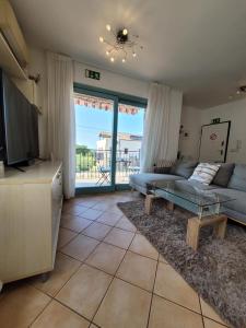 ein Wohnzimmer mit einem Sofa und einem TV in der Unterkunft Jovì`s Apartment in Tar