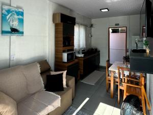 a living room with a couch and a table and a kitchen at CASA CLIMATIZADA COM HIDROMASSAGEM PRÓXIMO BETO CARRERO E PRAIAS - Casa 1 DuMar Hospedagem in Penha