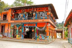 an orange building with a balcony and a store at Casa Puente de Boyaca in Tunja