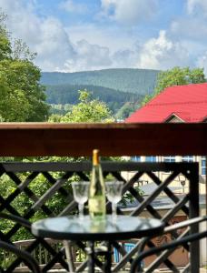 a bottle of champagne and two glasses on a table at Królewna Śnieżka II in Szklarska Poręba