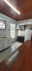 Una cocina con una mesa de madera en una habitación. en Casa floresta casal, en Campos do Jordão