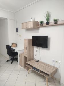 a living room with a desk and a tv on a wall at Olga & Dimitris in Kalamata