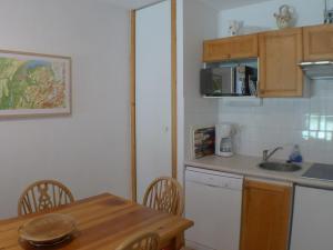 een keuken met een wastafel en een tafel met stoelen bij Appartement Samoëns, 3 pièces, 6 personnes - FR-1-629-106 in Samoëns