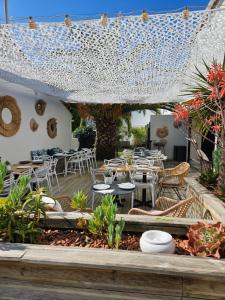 een patio met tafels en stoelen en een boom bij Hôtel Ancre Marine & Spa Thalgo *** in Noirmoutier-en-l'lle