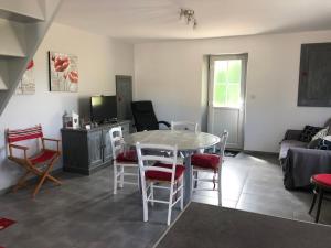 a living room with a table and chairs at petite maison in La Haye-dʼEctot