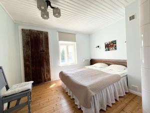 una camera bianca con un letto e una finestra di Tulbi Guesthouse a Pärnu