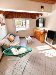 a living room with a couch and a tv at Las Araucarias Caviahue in Caviahue