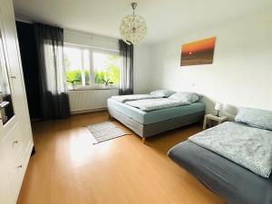 a bedroom with two beds and a chandelier at Panorama-Haus Wohnung Säntis in Wangen im Allgäu +10 photos