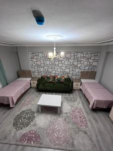 ein Wohnzimmer mit 2 Betten und einem Sofa in der Unterkunft YALI Apart Hotel in Trabzon