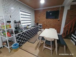 a kitchen with a table and chairs in a room at D'Maro Hut Mesilou in Kampong Kundassan