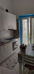 a kitchen with white cabinets and a table with a table sidx sidx sidx at Casadduoglio home costa d'Amalfi in Vietri sul Mare