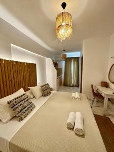 1 dormitorio con 1 cama grande y toallas. en Athina Rooms - Lounge Apartments, en Parikia