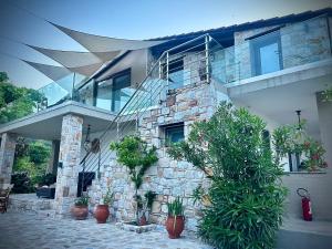 un bâtiment en pierre avec des plantes en pot devant lui dans l'établissement Natura Bungalows, à Thasos