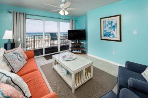 een woonkamer met een bank en een tv bij Gulf Dunes 208: Beautifully remodeled condo, fee beach chairs, tennis court in Fort Walton Beach