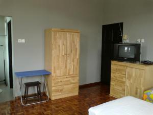 a bedroom with a bed and a desk and a television at Pan Homestay in Kuantan