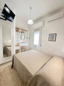 um quarto branco com uma cama e um espelho em Hotel Amelia em Fano