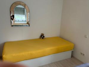 a yellow bed in a room with a window at Monteurwohnung Viersen Central in Viersen
