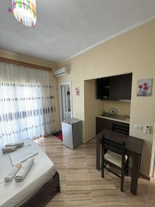 a bedroom with a bed and a desk and a kitchen at Adrian Agustin Rooms in Lukovë