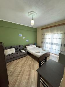 a small room with two beds and a couch at Adrian Agustin Rooms in Lukovë