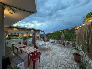 a patio with tables and chairs and a pool at Adrian Agustin Rooms in Lukovë