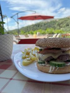 a sandwich and fries on a plate on a table at Adrian Agustin Rooms in Lukovë