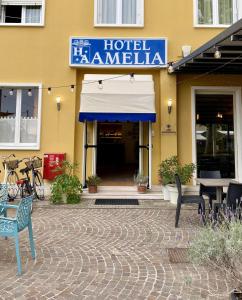 um hotel Hameln com mesas e cadeiras em frente a um edifício em Hotel Amelia em Fano