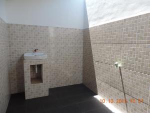 a bathroom with a sink and tiled walls at Yaya Bungalows Blue Coral in Gili Meno