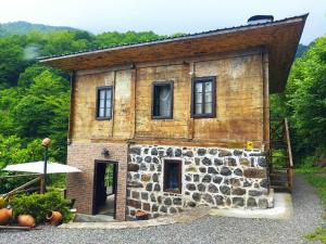 a small stone house with a roof on top at odahouse. fireplace and spring water. in Batumi