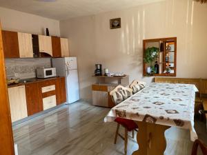uma cozinha com uma mesa e uma cozinha com um frigorífico em Pensiunea Răzvan em Gura Riului